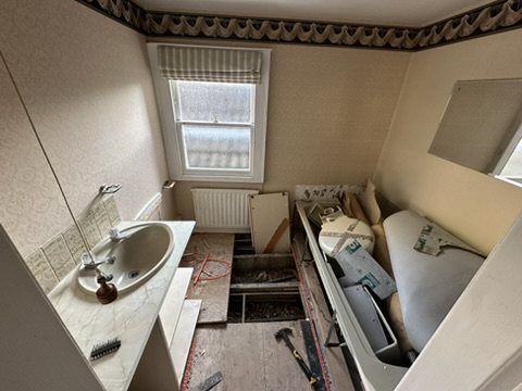 The bathroom before work, with the old bath and basin