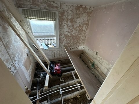 Floor opened to the joists with pipework exposed