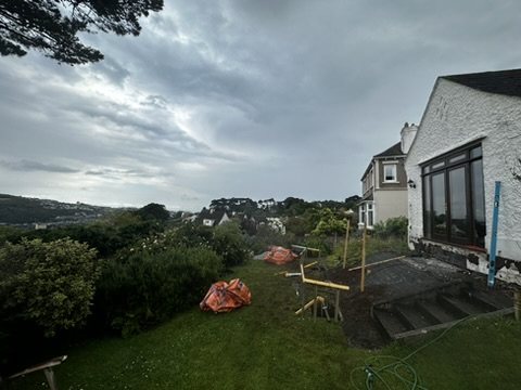 The sloping garden before work, with setting-out pegs