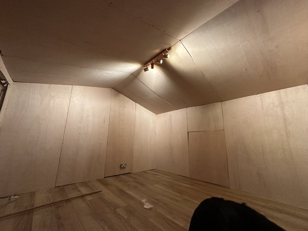 The same room lined in ply with track lighting