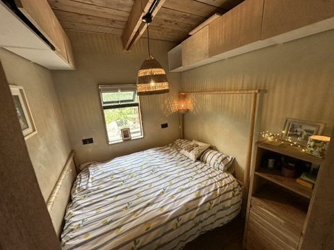 Finished bedroom with timber ceiling and fitted shelving