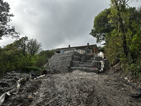 The sloping plot cleared and terraced with gabion walls